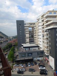 a large building with cars parked in a parking lot at Panoramic apartment in Shkodër
