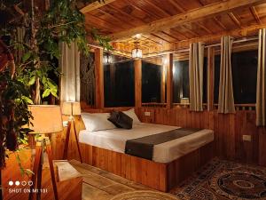سرير أو أسرّة في غرفة في The Tree Top Treehouse Jibhi