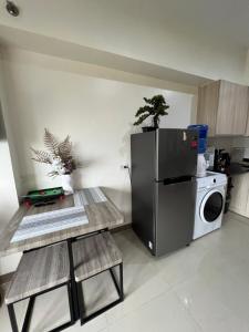 a kitchen with a refrigerator and a washing machine at Cozy Studio, super fast internet, workspace and washer in Cebu City