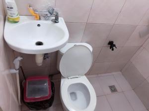y baño con aseo blanco y lavamanos. en Min Hao&Xin Transient, en Manila