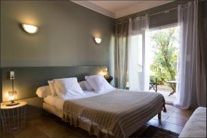 a bedroom with a bed and a large window at Hotel-Restaurant Le Vieux Moulin in Centuri