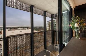 a balcony with a table and a vase of flowers at The Retreat Adelaide in Adelaide