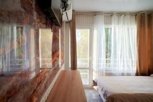 ein Schlafzimmer mit einem Bett und einem großen Fenster in der Unterkunft Blue Kokilia in Chilia Veche