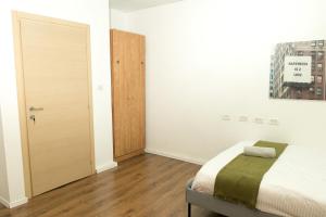a bedroom with a bed and a wooden door at kotel apartment in Jerusalem