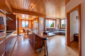 a kitchen and living room with a couch at Alpe Fleurie Residence in Villars-sur-Ollon
