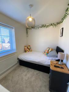 1 Schlafzimmer mit 2 Betten, einem Tisch und einem Fenster in der Unterkunft Single bedroom - Hampton Water, Peterborough in Peterborough