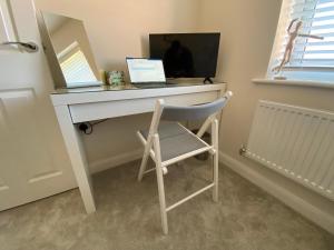 a desk with a laptop computer on top of it at Single bedroom - Hampton Water, Peterborough in Peterborough