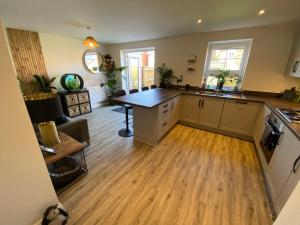 a kitchen with a wooden floor and a table at Single bedroom - Hampton Water, Peterborough in Peterborough