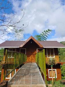 una pasarela de madera que conduce a una casa en Don's River Valley Jungle Resort, en Maraiyūr