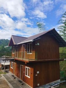 a large wooden house with a balcony at Don's River Valley Jungle Resort in Maraiyūr