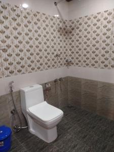 baño con aseo blanco en una habitación en Don's River Valley Jungle Resort, en Maraiyūr