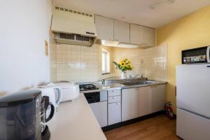 a small kitchen with a sink and a refrigerator at SHIONE in Otaru