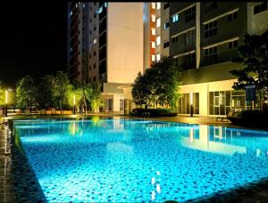 una gran piscina por la noche con luces azules en AF Homestay 15mins to KLIA FREE WIFI NETFLIX, en Sepang