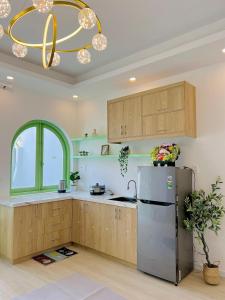 a kitchen with a refrigerator and a chandelier at HaHe Homestay in Da Lat