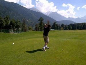 a man throwing a frisbee on a green field at Hotel Crown Pine Pahalgam in Anantnāg