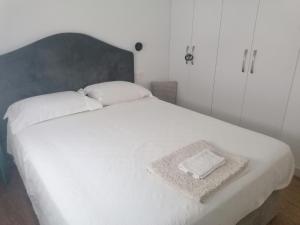 1 dormitorio con 1 cama blanca grande y cabecero gris en El Manzanal - gateway to the mountains and Bilbao, en Llodio