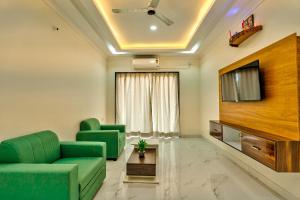 a living room with green furniture and a flat screen tv at JOE PHILLPE APARTMENT in Old Goa