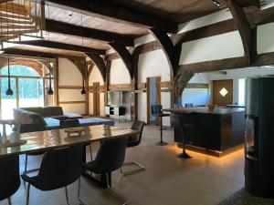 a living room with wooden ceilings and tables and chairs at Heuerhaus - Artlands Home- Landhaus für Familien und Gruppen in Badbergen +8 photos