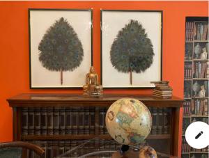 a book shelf with two paintings of trees on it at Suite Lago blu in Gravedona