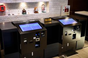 twee pinautomaten met schermen erop bij Hotel Keihan Asakusa in Tokyo