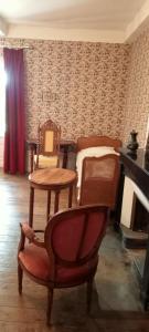 a living room with a bed and a table and a chair at Manoir de Tourville in Les Halles