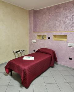 ein Schlafzimmer mit einem Bett mit einer roten Decke in der Unterkunft HomeFamily in Lido di Ostia