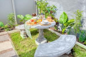 a table and a chair in a garden at Hampton Collection - 2 Sleeper Serviced Studio Apartment with Pool in Durban