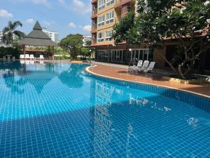 a large blue swimming pool next to a building at H2DO Hotel in Ban Khlong Sanam Phli