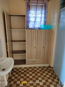 a bathroom with a sink and a toilet and a cabinet at VOI HIGHWAY BNB in Voi