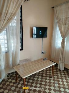 a wooden bench in a room with windows at VOI HIGHWAY BNB in Voi