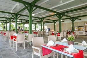 un restaurant avec des tables, des chaises et des serviettes rouges dans l'établissement Crystal Boutique Beach & Resort - Adult Only, à Belek