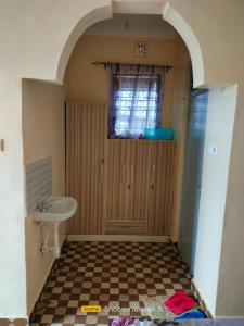 ein Bad mit einem Waschbecken und eine Tür mit einem Fenster in der Unterkunft VOI HIGHWAY BNB in Voi
