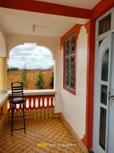 a chair sitting on a porch with a window at VOI HIGHWAY BNB in Voi