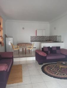 ein Wohnzimmer mit lila Sofas und einem Tisch in der Unterkunft appartamenti Oueslati in Houmt Souk