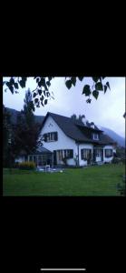 a large white house sitting on top of a field at La maison du petit bonheur in Moutier