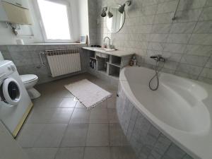 a bathroom with a tub and a toilet and a sink at 2br condo in the heart of Zagreb in Zagreb +14 photos