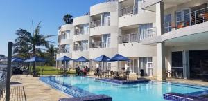 un hotel con piscina frente a un edificio en Riviera Hotel Hartenbos, en Mossel Bay