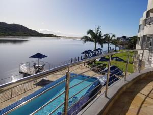 uma piscina ao lado de uma massa de água em Riviera Hotel Hartenbos em Mossel Bay