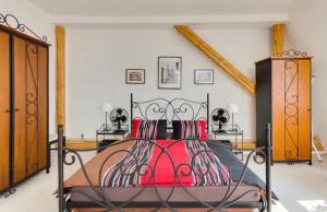 a bedroom with a large bed with red pillows at Lenka's cozy Red studio + Lenka's cozy Gold apartment in Prague
