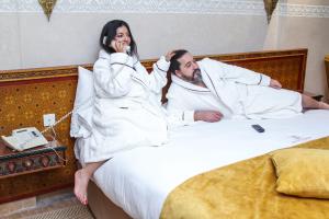 a man and a woman laying on a bed at Borj Des Cascades & Spa in Ouzoud