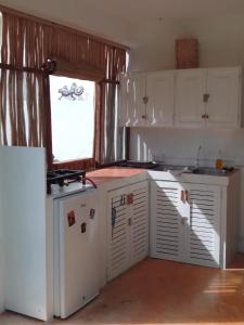 a kitchen with white cabinets and a window at NEW MORINGA in Las Terrenas
