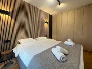 a bedroom with a large bed with towels on it at Apartman Magi Jahorina in Jahorina