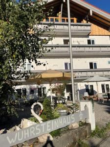 eine Terrasse mit einem Sonnenschirm und einem Gebäude in der Unterkunft WuhrsteinHaus in Schleching