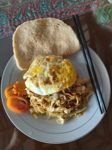 un plato de comida con un huevo y una tostada en Shoreside Semat Villa and Flat en Jepara
