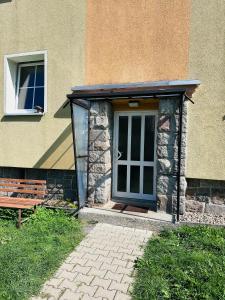 a building with a door and a bench in front of it at Ferienwohnung Johanngeorgenstadt in Johanngeorgenstadt