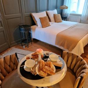een kamer met een bed en een dienblad met eten op een tafel bij Le 11 en Pévèle in Templeuve