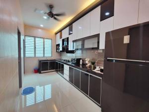 a kitchen with black and white cabinets and a ceiling fan at JPP Austin市区 3马力中央冷气 自动麻将机 游戏机 6分钟到 tebrau aeon toppen lotus in Johor Bahru