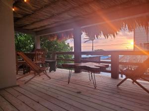 eine Veranda mit einem Tisch und Stühlen sowie einem Sonnenuntergang in der Unterkunft The Bounty in Caye Caulker