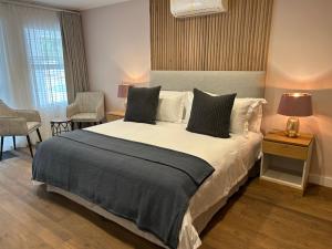 a bedroom with a large bed and two chairs at Mirabelle Guesthouse in Franschhoek