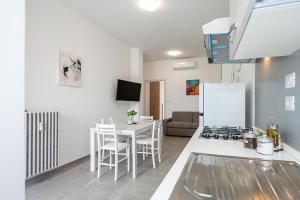 a kitchen and living room with a table and a refrigerator at Appartamento Esclusivo - Zona Metro Massaua-Marche Torino in Turin